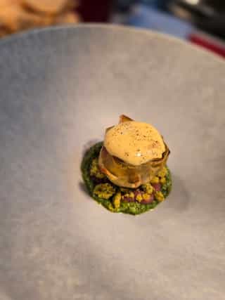 Alcachofas con pesto de menta, perejil y rúcula, crema de cebolla y carbonara