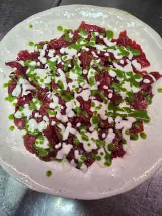 Carpaccio de ternera con emulsión de parmesano y rúcula